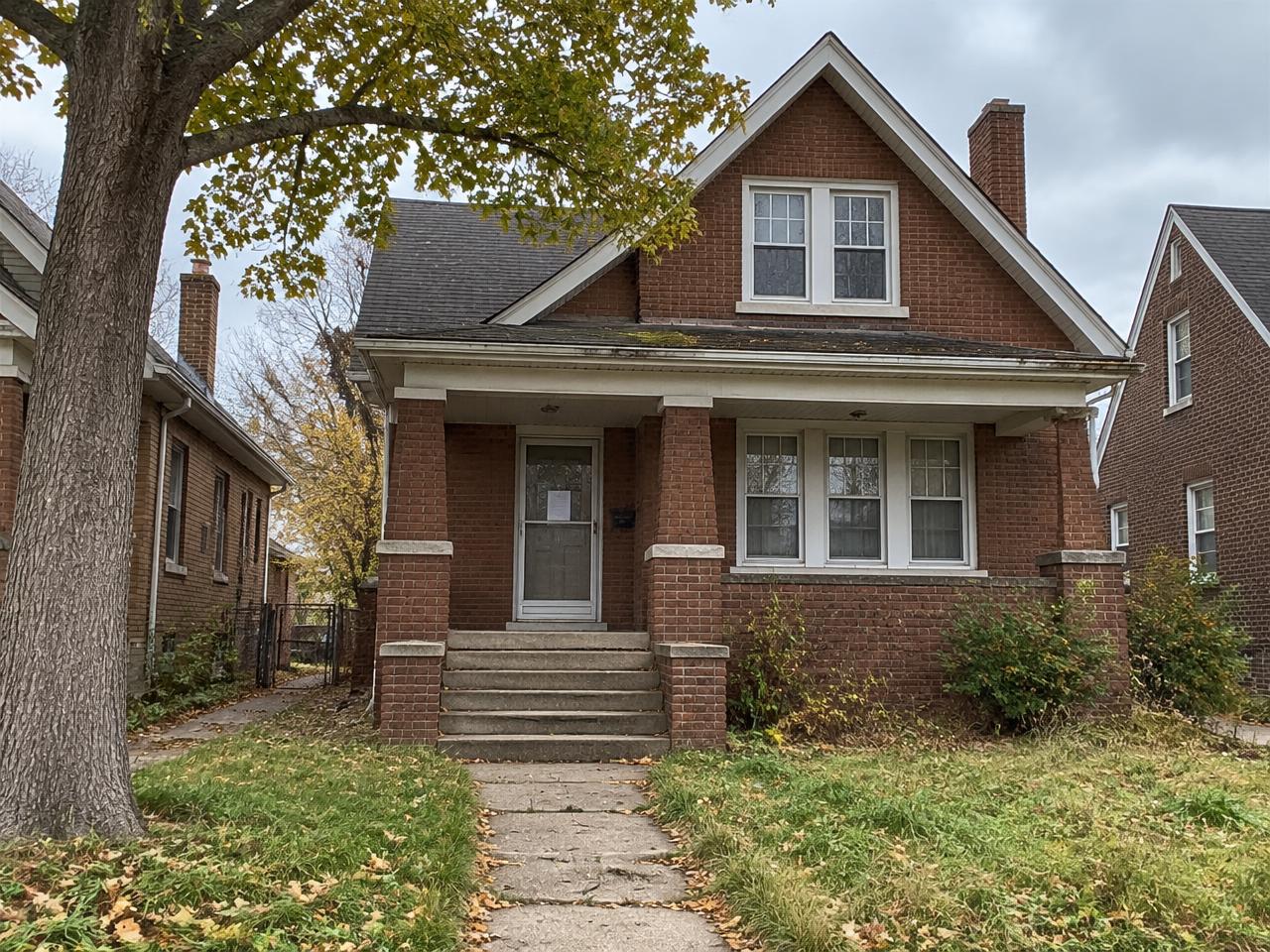 Detroit brick bungalow in preforeclosure with a notice taped to the storm door